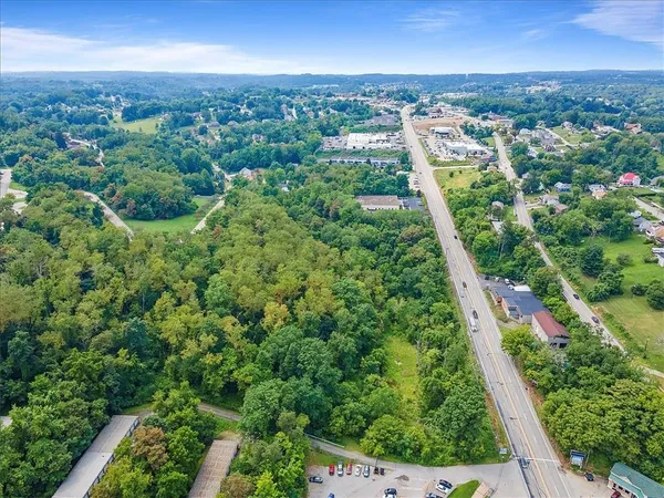 an aerial view of residential houses with outdoor space and trees