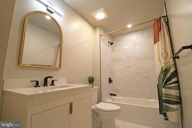 a bathroom with a granite countertop toilet a sink and shower