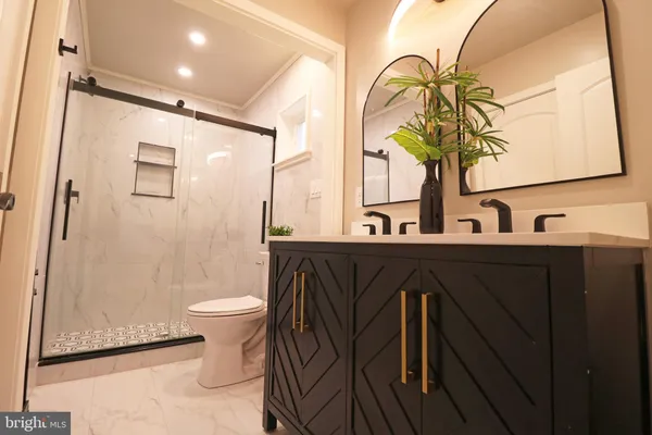 a kitchen with stainless steel appliances kitchen island granite countertop a table chairs and a wooden floor