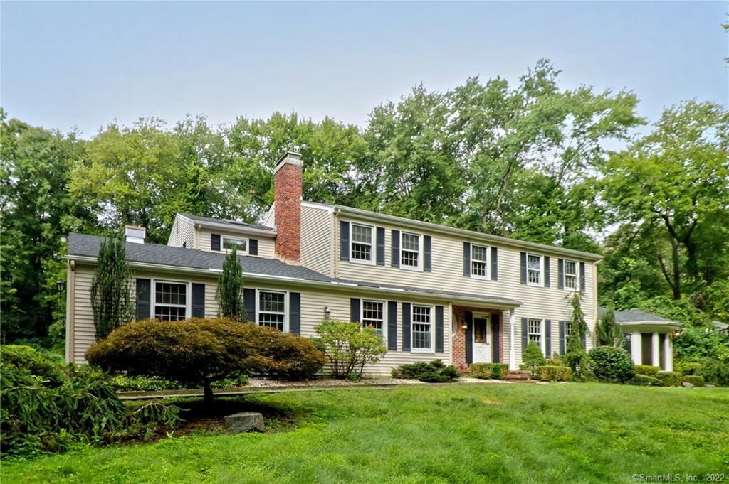 10 Beecher Road Woodbridge, CT 06525 - Photo 1 of 1 a front view of a house with a garden and trees