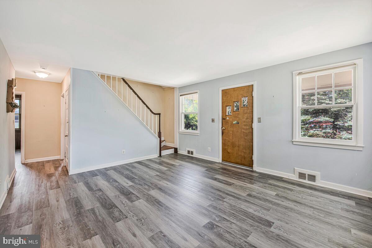 9425 Washington Boulevard Lanham, MD 20706 - Photo 7 of 38 a view of an empty room with wooden floor and a window
