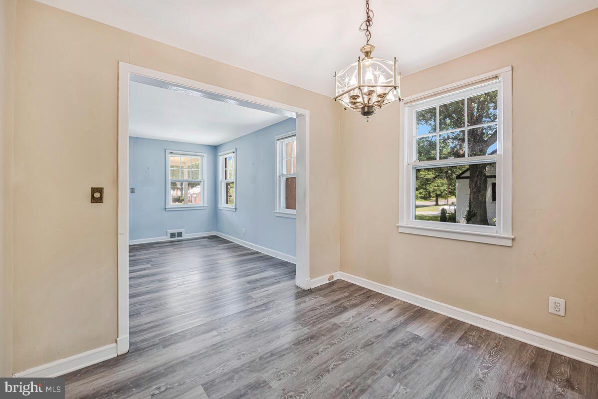 9425 Washington Boulevard Lanham, MD 20706 - Photo 10 of 38 an empty room with wooden floor chandelier and windows