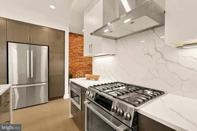 a kitchen with stainless steel appliances granite countertop a refrigerator and a stove