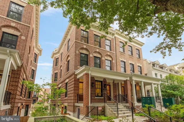 a front view of a multi story residential apartment building with a yard