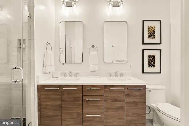 a bathroom with a double vanity sink mirror and toilet