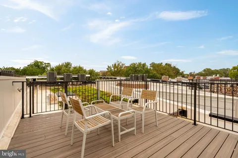 a view of a balcony with chairs and wooden floor