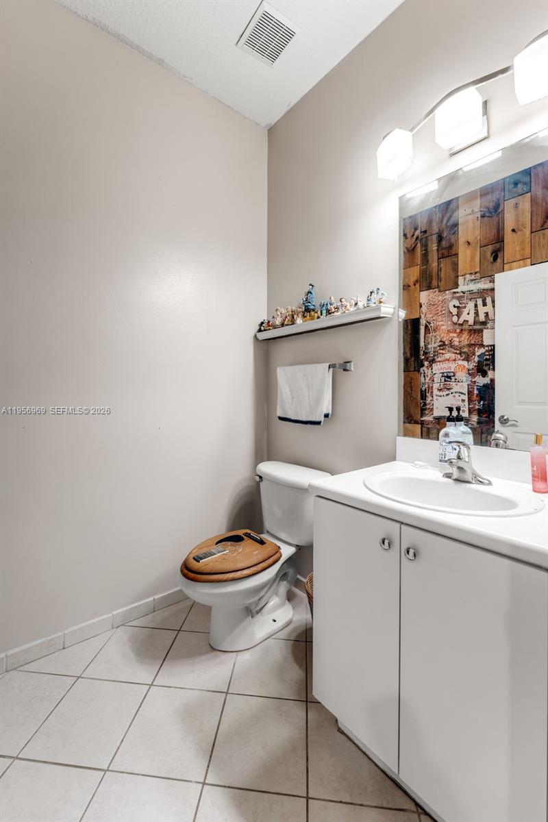 12965 Southwest 133rd Terrace Miami, FL 33186 - Photo 12 of 42 a bathroom with a toilet sink and mirror