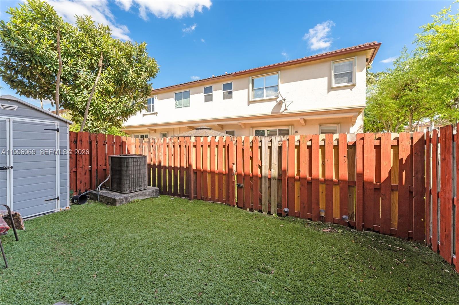 12965 Southwest 133rd Terrace Miami, FL 33186 - Photo 27 of 42 a backyard of a house with lots of green space and wooden fence