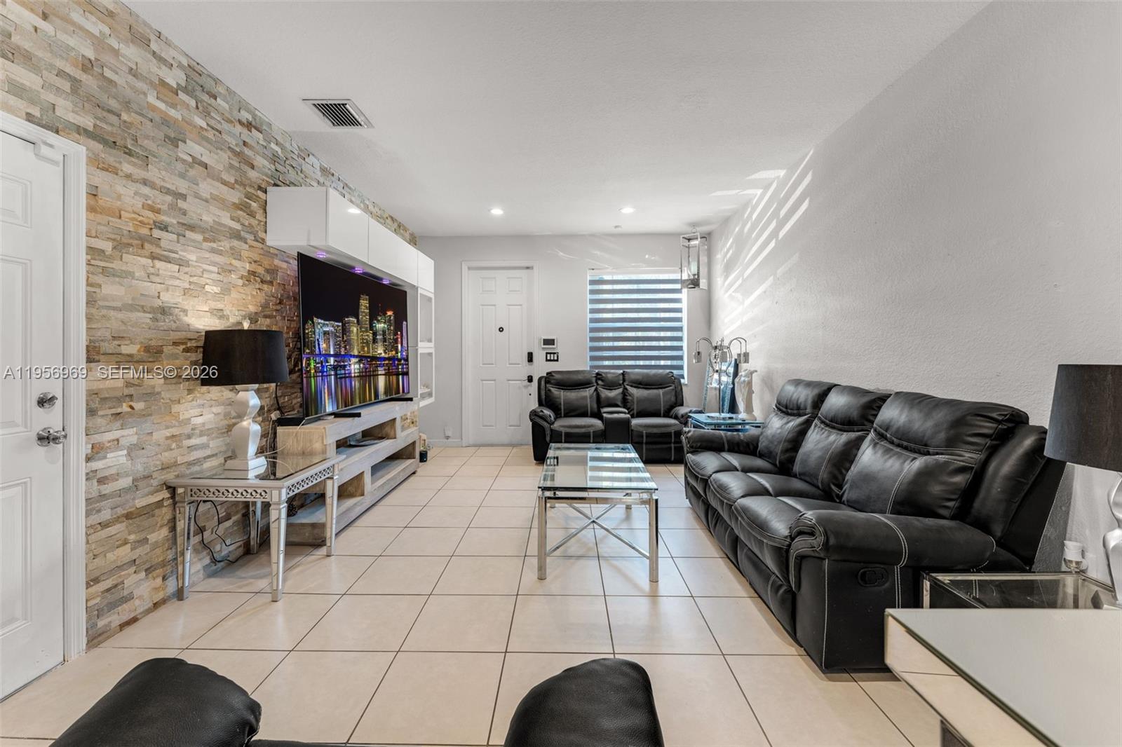 12965 Southwest 133rd Terrace Miami, FL 33186 - Photo 6 of 42 a living room with furniture a flat screen tv and kitchen view