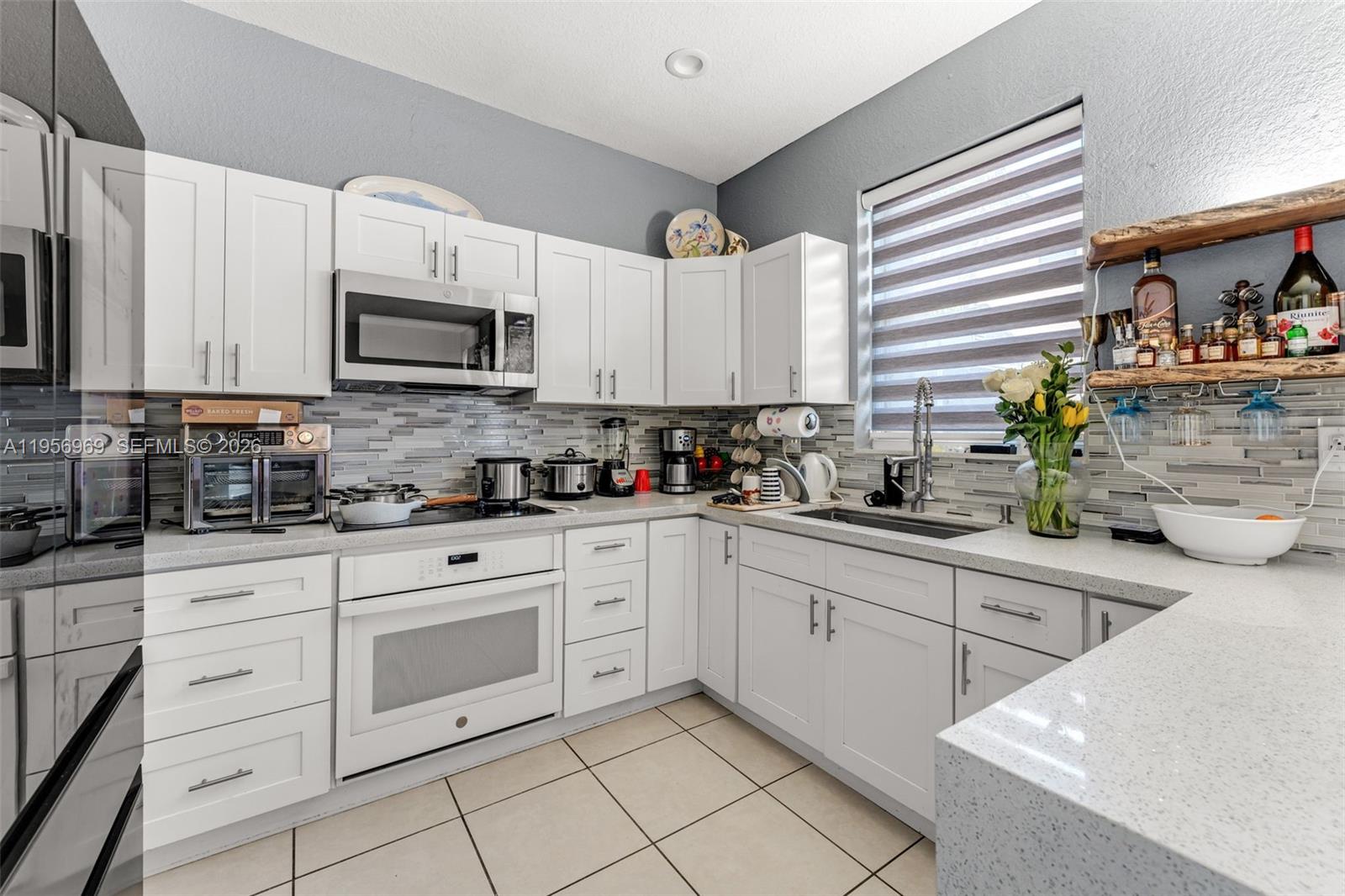 12965 Southwest 133rd Terrace Miami, FL 33186 - Photo 10 of 42 a kitchen with white cabinets and appliances