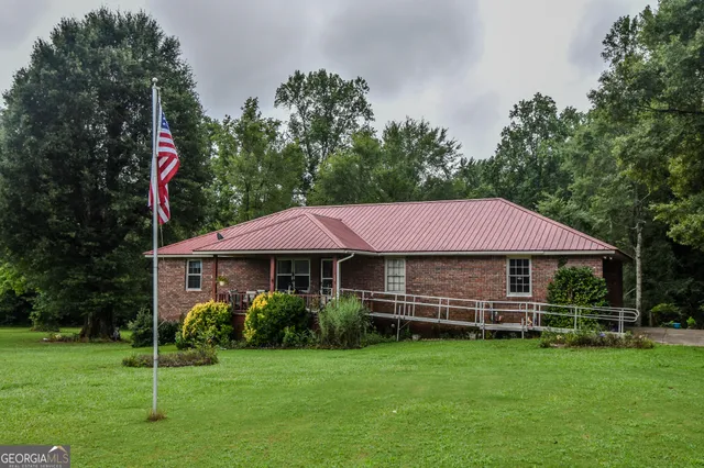 a front view of a house with a yard and trees