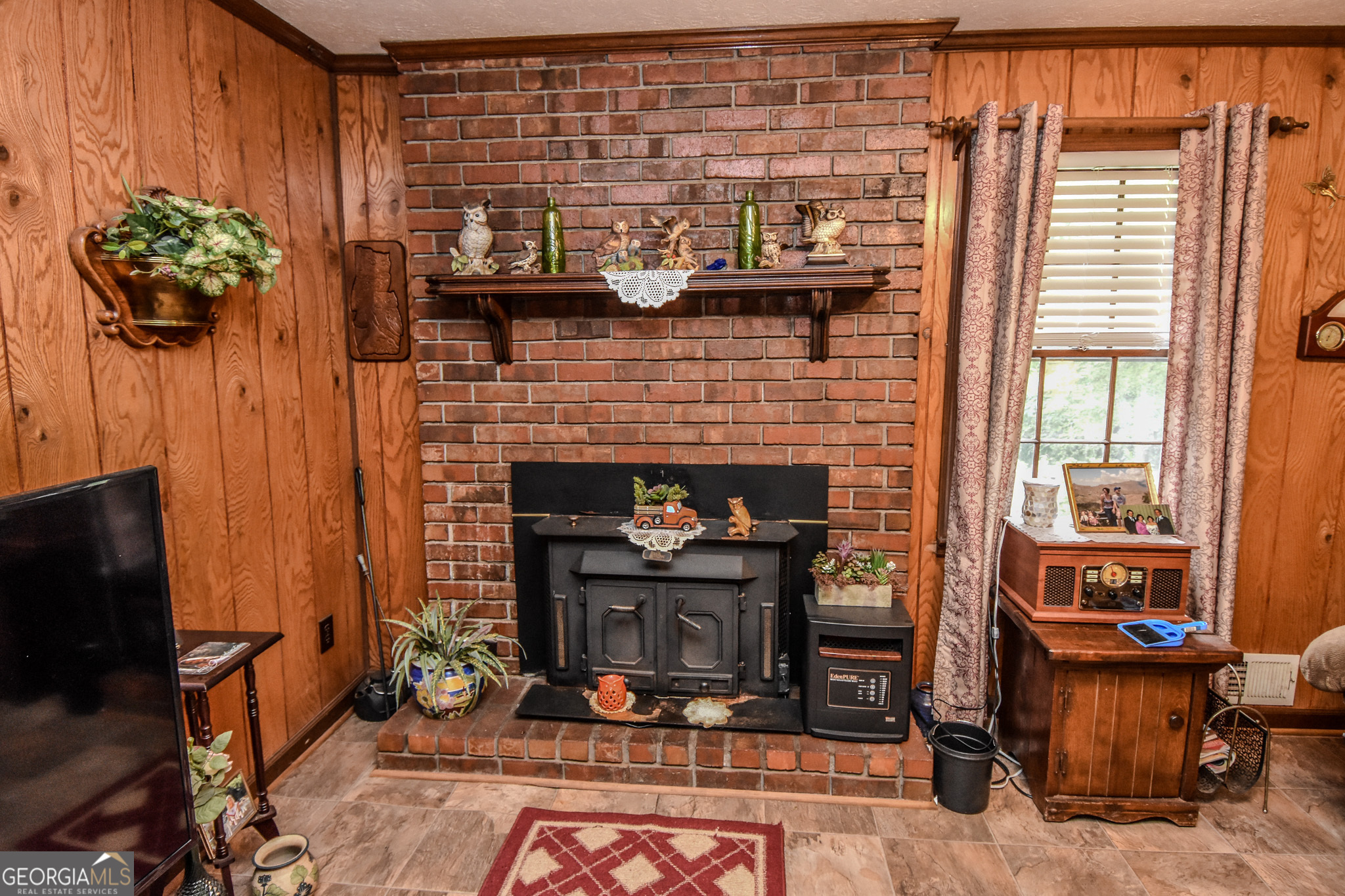 223 Ward Road Williamson, GA 30292 - Photo 27 of 51 a living room with furniture a fireplace and a potted plant