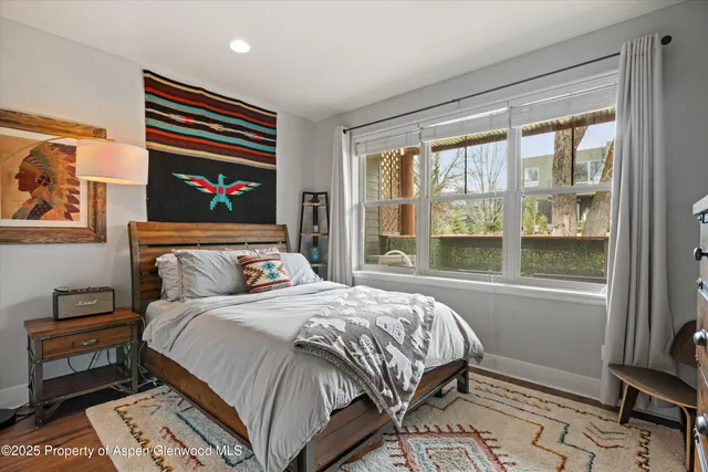 a bed sitting in a bedroom next to a window