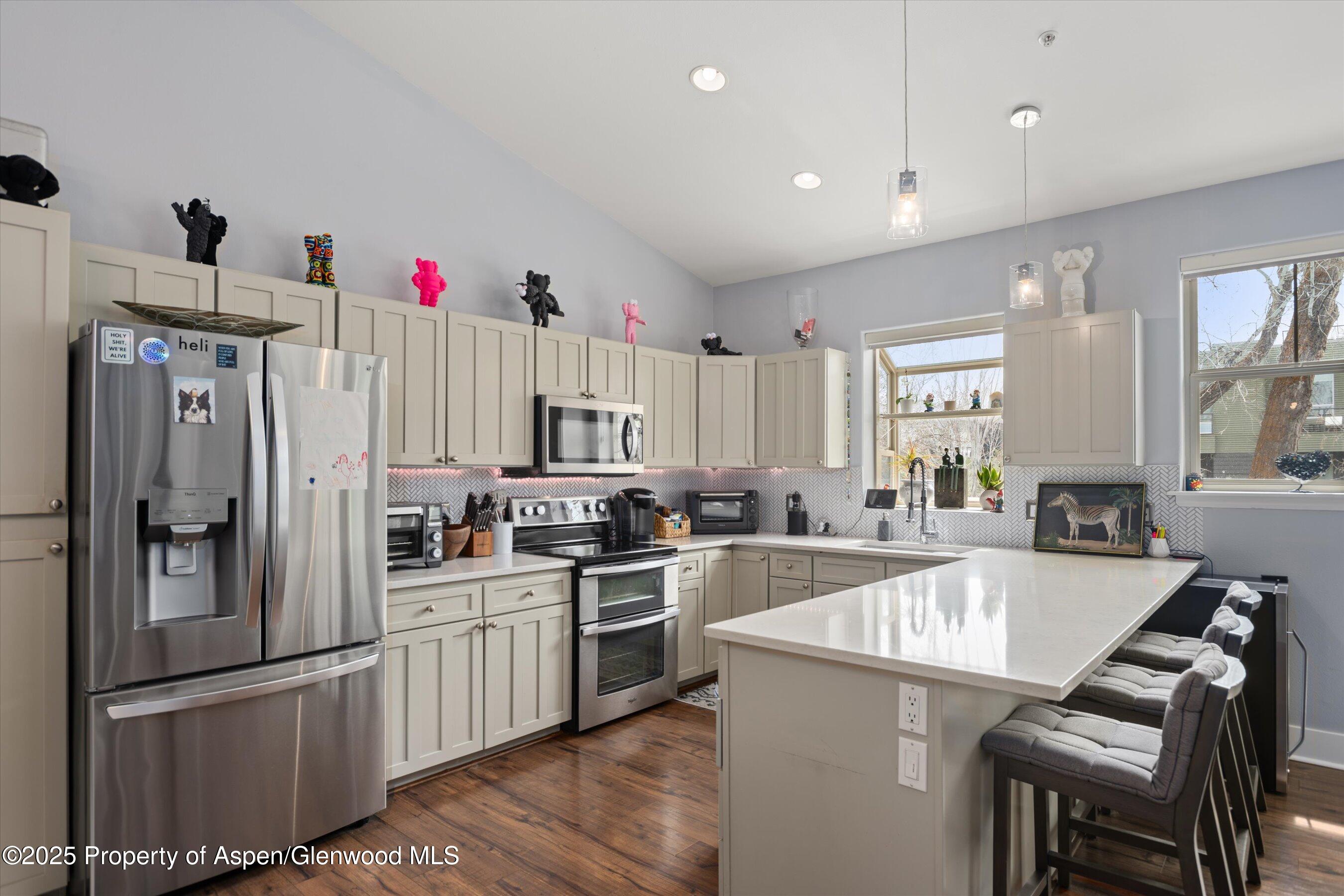 712 Evans Court Basalt, CO 81621 - Photo 7 of 23 a kitchen with white cabinets and stainless steel appliances
