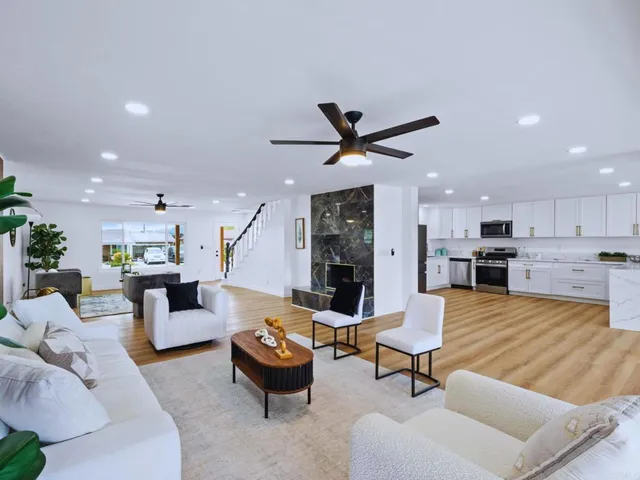 a living room with furniture kitchen view and a potted plant