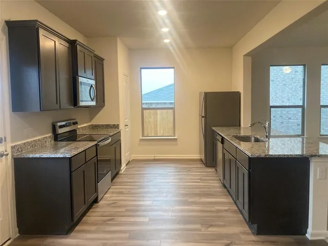 a kitchen with counter top space and wooden floor