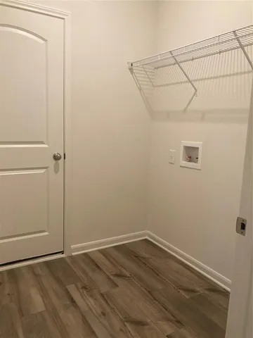 an empty room with wooden floor and cabinet