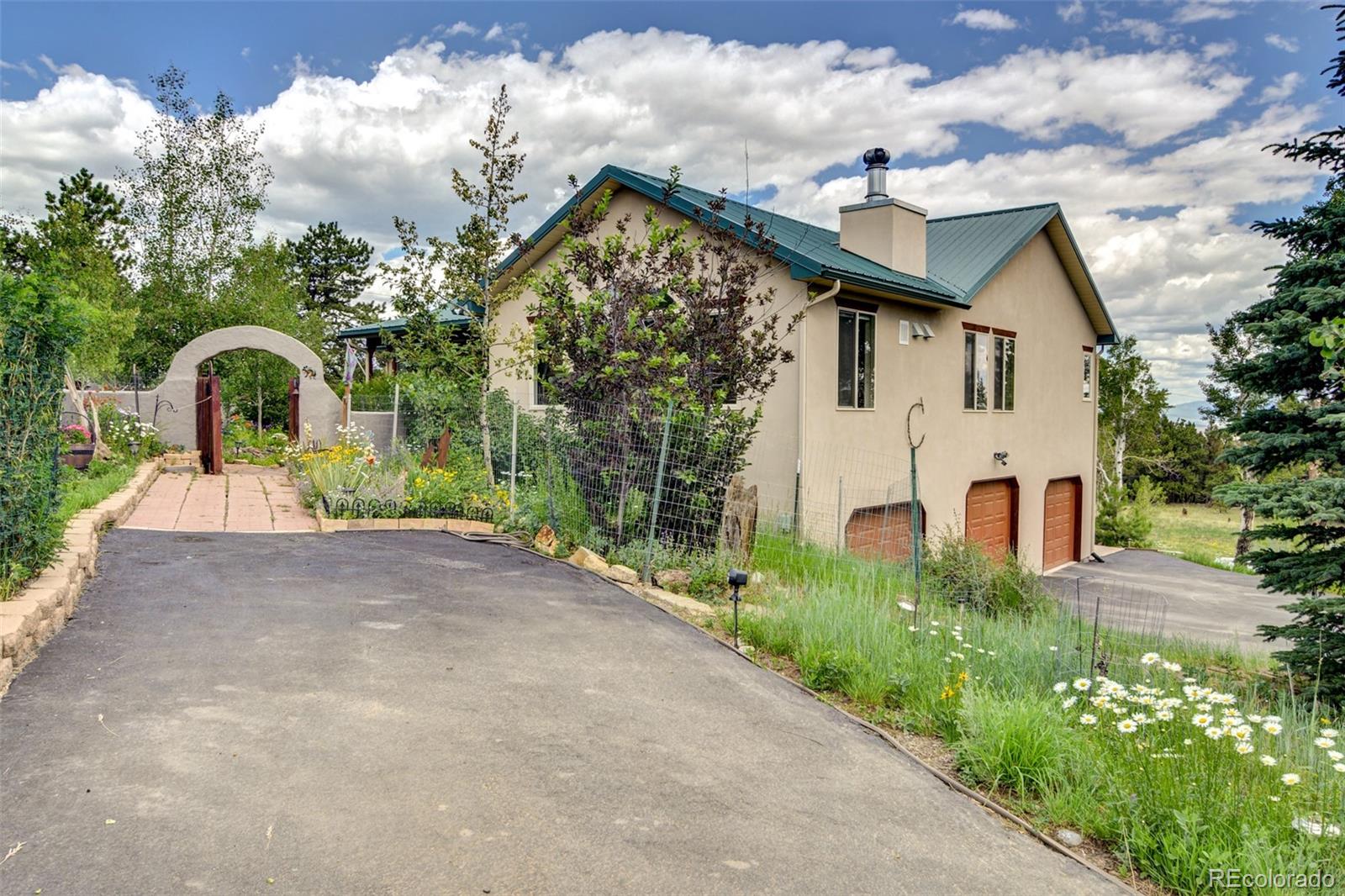 3135 Singletree Road Hartsel, CO 80449 - Photo 1 of 40 a front view of a house with a yard and trees