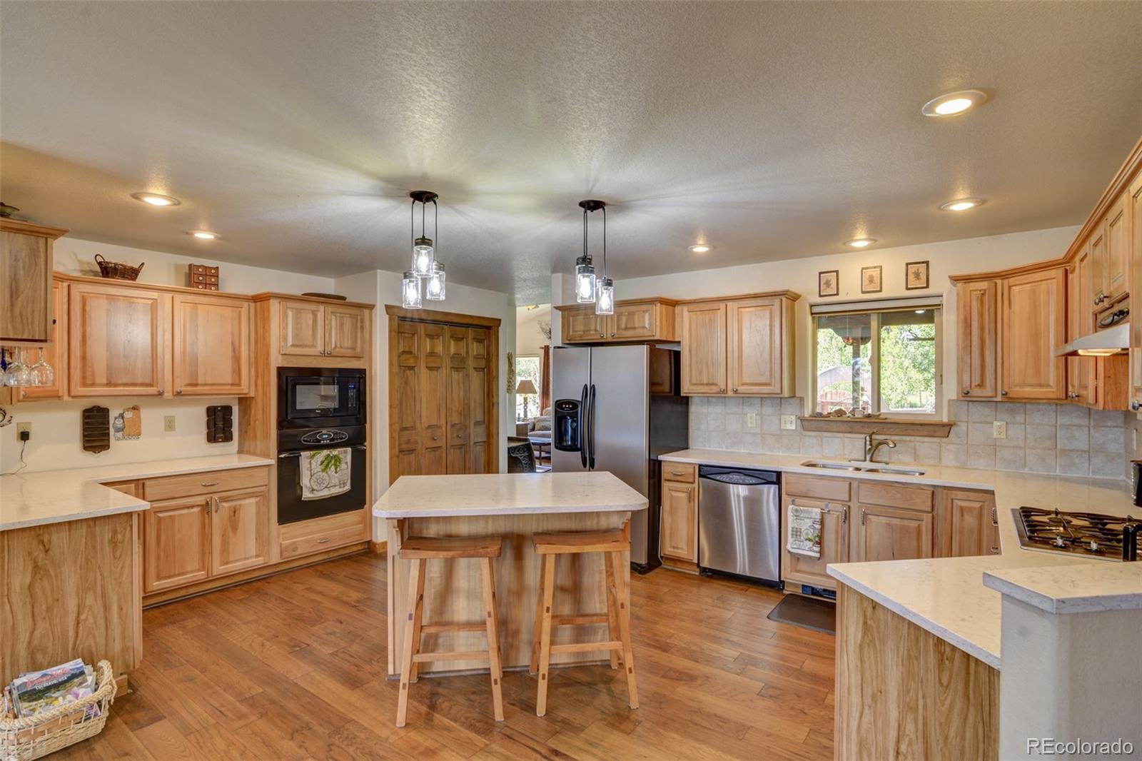 3135 Singletree Road Hartsel, CO 80449 - Photo 11 of 40 a large kitchen with cabinets chairs and wooden floor