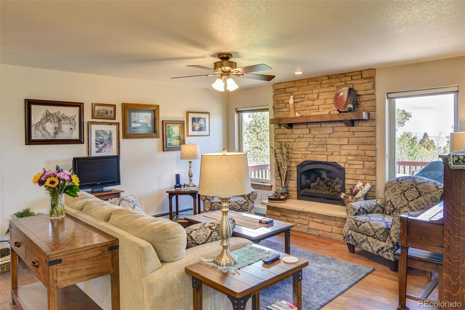 3135 Singletree Road Hartsel, CO 80449 - Photo 16 of 40 a living room with furniture a fireplace and a table