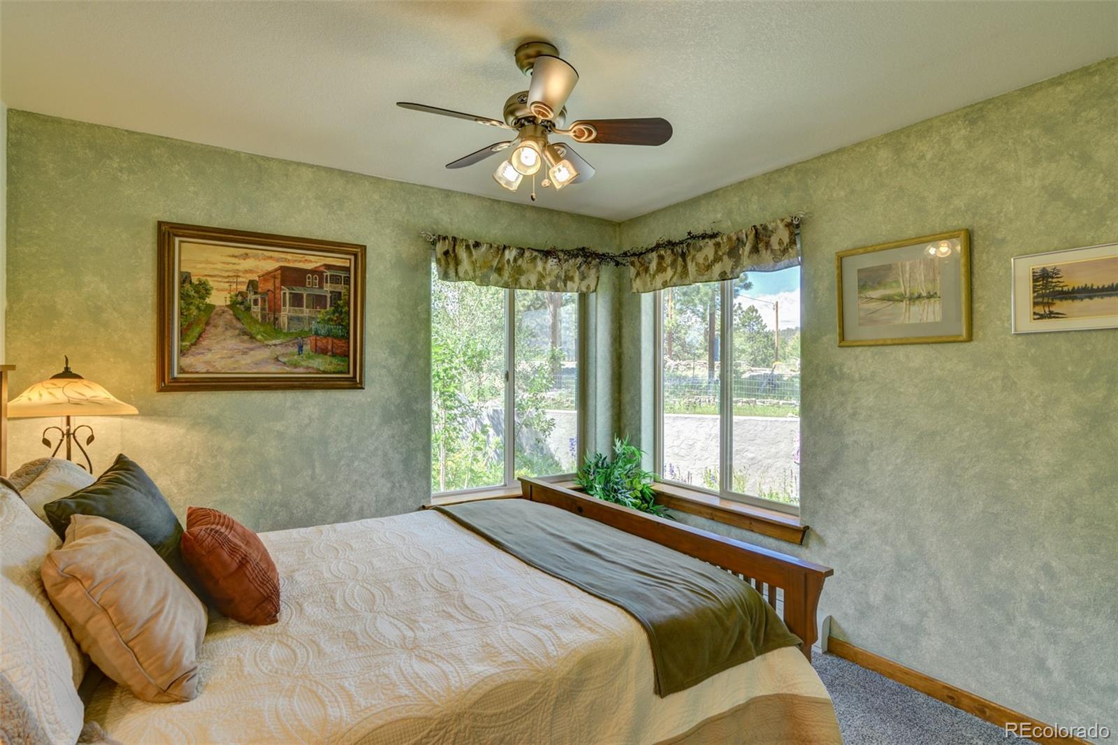3135 Singletree Road Hartsel, CO 80449 - Photo 23 of 40 a bedroom with a large bed and a chandelier