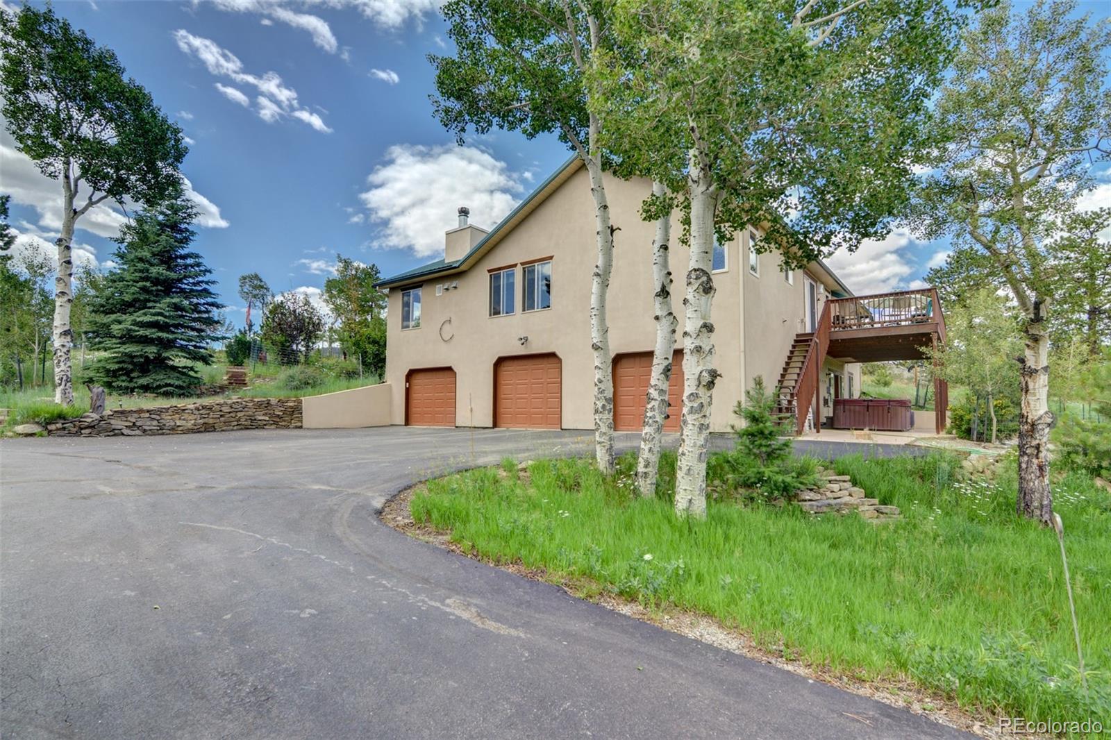 3135 Singletree Road Hartsel, CO 80449 - Photo 4 of 40 a view of a white house with a big yard and large tree