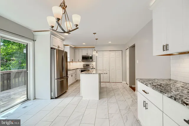 a kitchen with stainless steel appliances granite countertop a refrigerator and a stove top oven