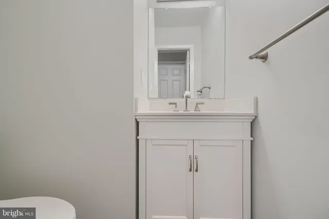 a bathroom with a sink vanity mirror and toilet