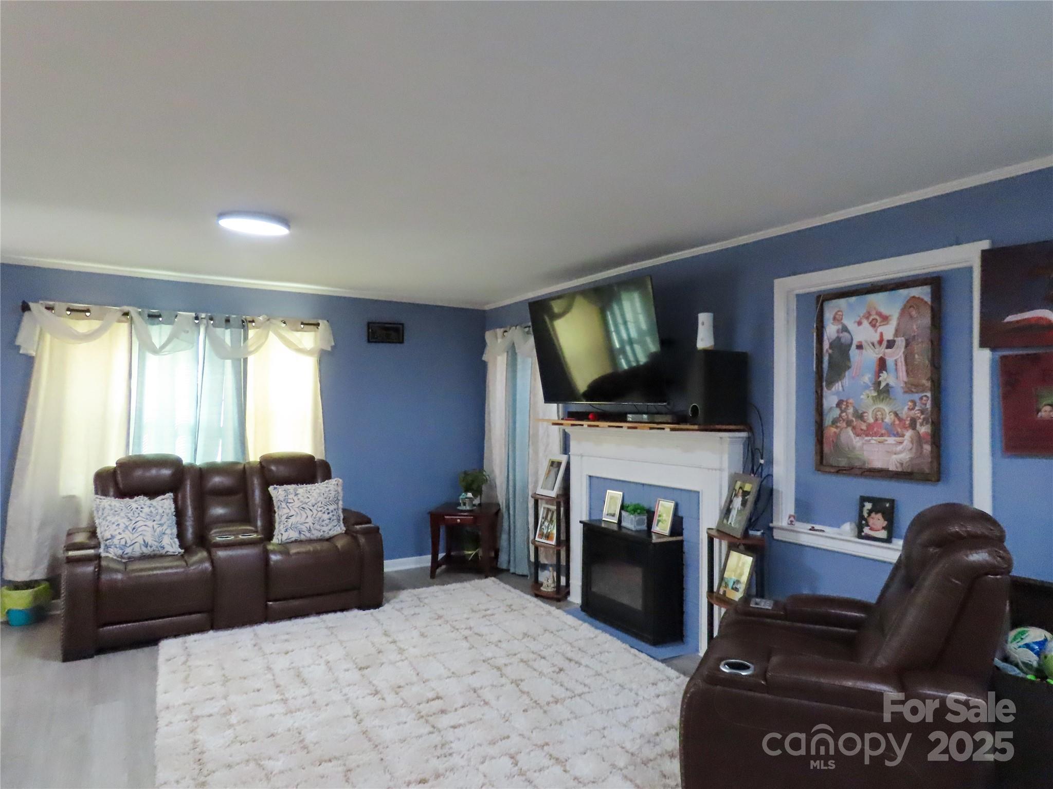 214 West Springs Street Lancaster, SC 29720 - Photo 13 of 33 a living room with furniture a flat screen tv and a fireplace
