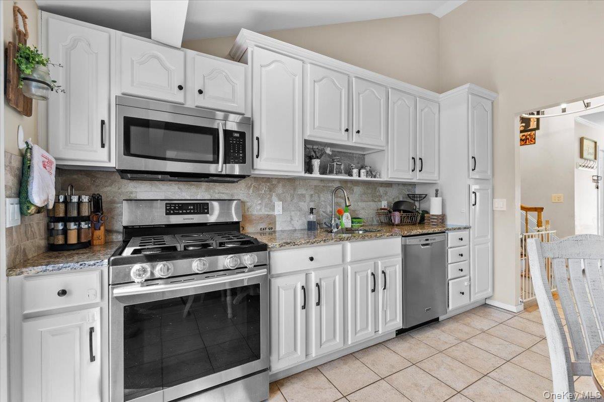 61 Winthrop Road Plainview, NY 11803 - Photo 12 of 37 a kitchen with stainless steel appliances granite countertop white cabinets a stove a sink and dishwasher