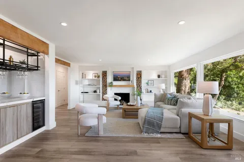 a living room with fireplace furniture and a large window