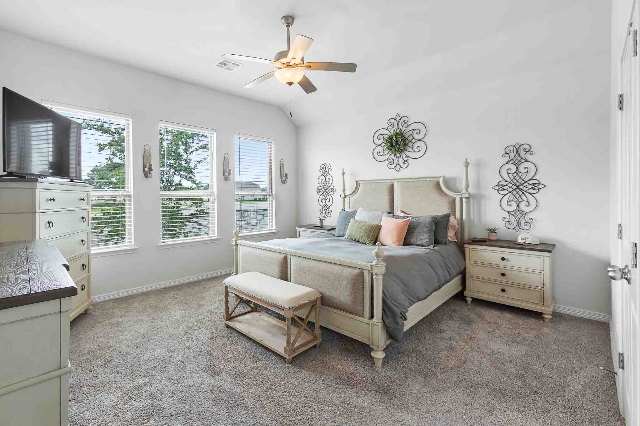166 West Branch Road Kyle, TX 78640 - Photo 14 of 39 Well-lit sleeping quarters with three windows overlooking the serene landscape and a ceiling fan for comfort.