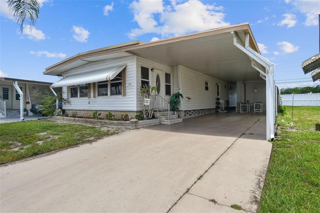 a front view of house with yard and trees around