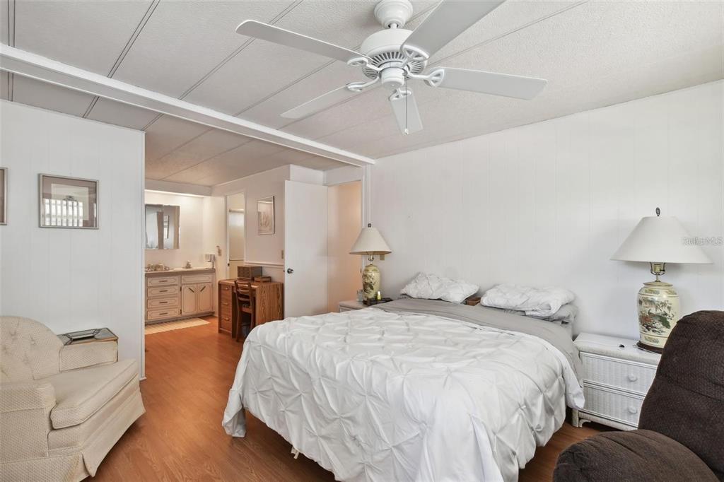 13225 101st Street Southeast, Unit 116 Largo, FL 33773 - Photo 13 of 22 a spacious bedroom with a bed couch chandelier and a window