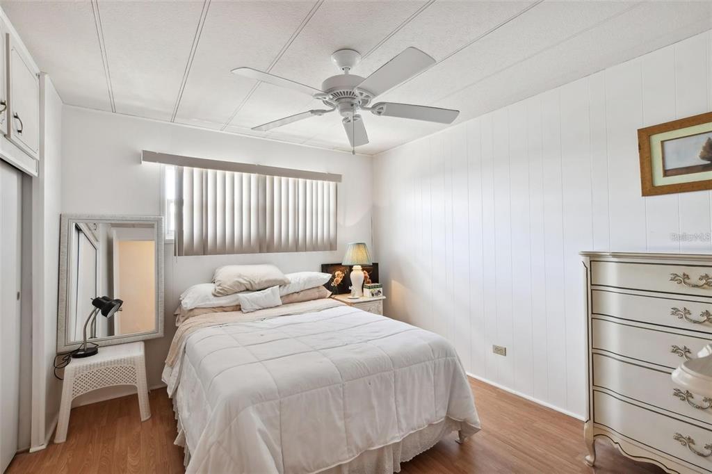 13225 101st Street Southeast, Unit 116 Largo, FL 33773 - Photo 16 of 22 a bedroom with a bed and a chandelier