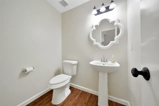 an empty room with wooden floor and a fireplace