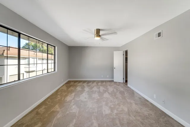 a bathroom with a granite countertop sink a toilet and a mirror