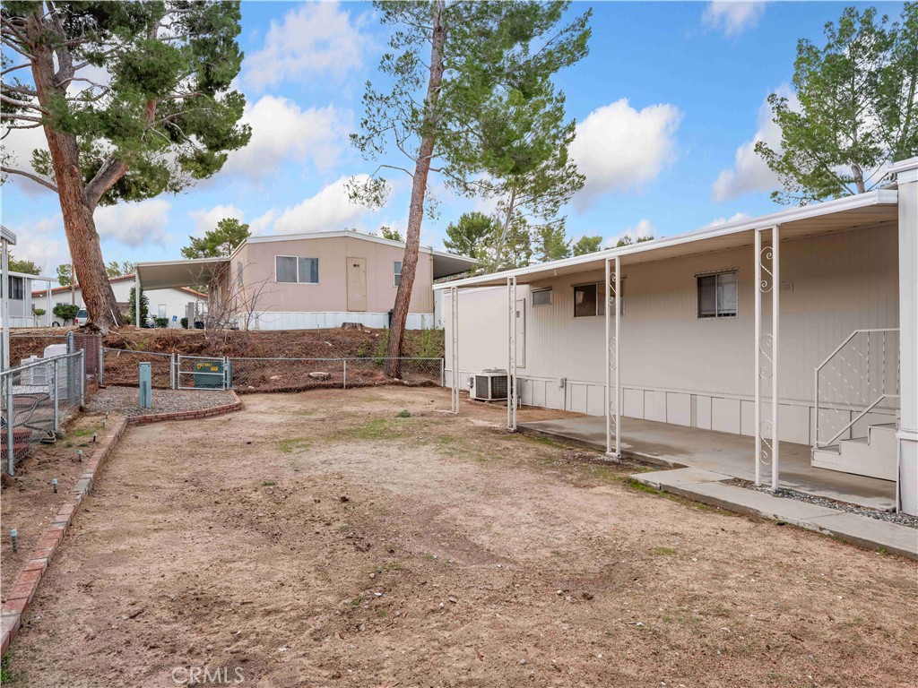 11414 Serra Road, Unit 46 Apple Valley, CA 92308 - Photo 19 of 22 a backyard of a house with barbeque oven fire pit table and chairs