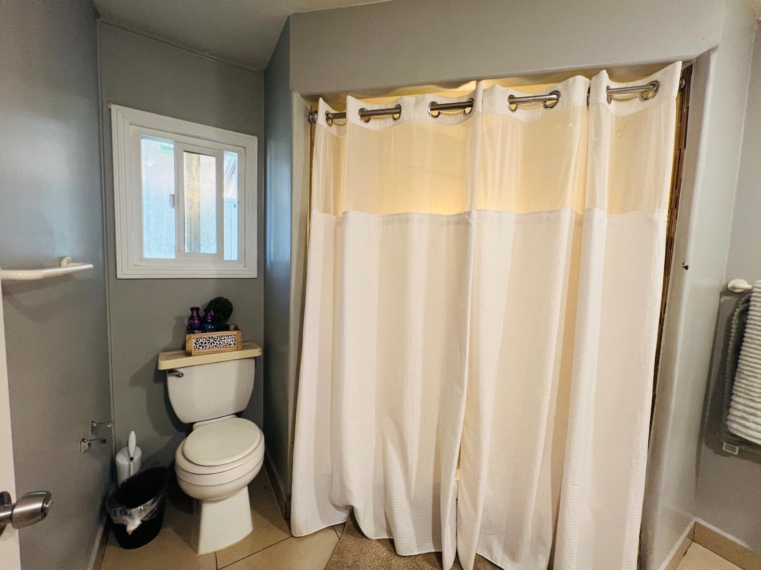 2845 East E Hatch Road, Unit 86 Ceres, CA 95351 - Photo 24 of 32 a bathroom with a toilet and a shower curtain