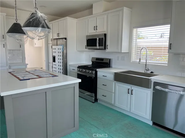 a kitchen with cabinets appliances a sink and a window