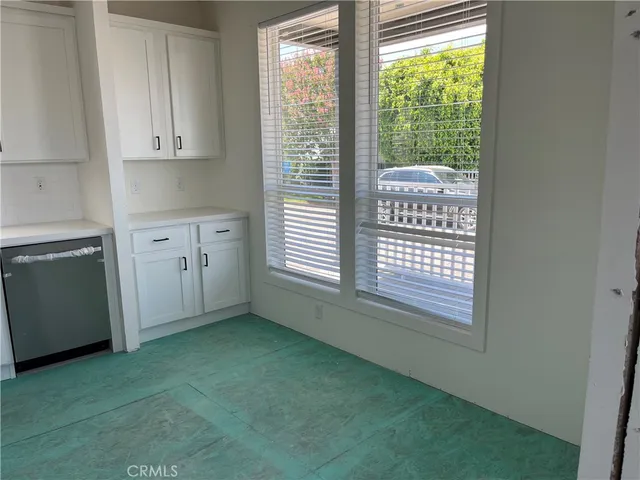 a view of a kitchen with a fridge and window