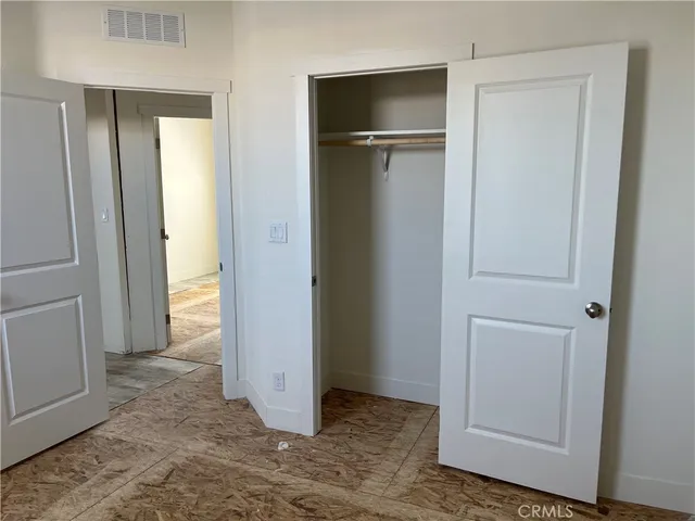 an empty room with closet and wooden floor