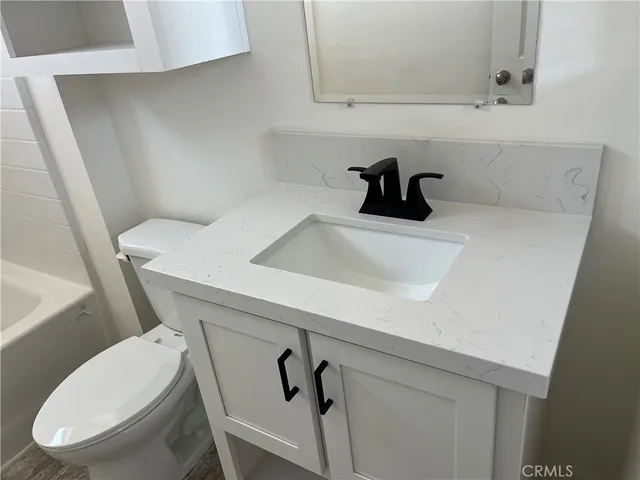 a bathroom with a bathtub sink vanity and mirror