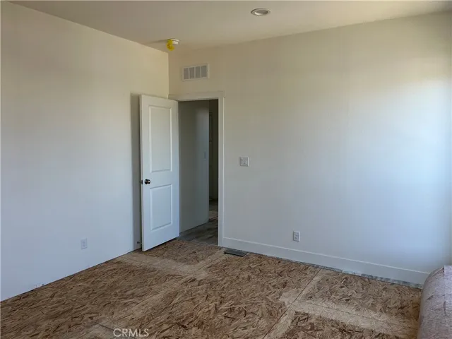 a view of a hallway with closet and wooden floor