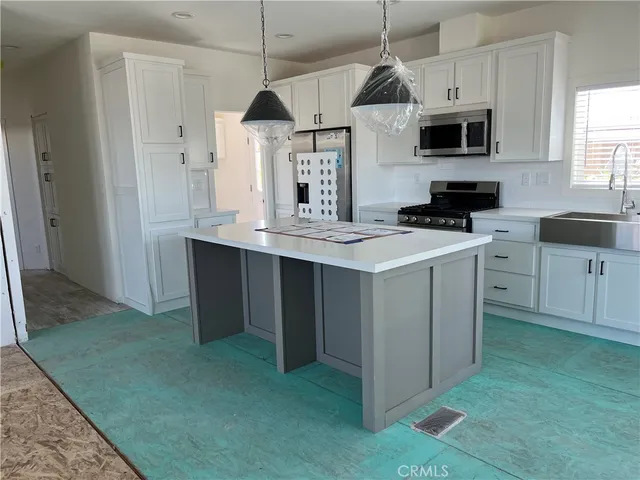 a kitchen with kitchen island a sink stainless steel appliances and cabinets