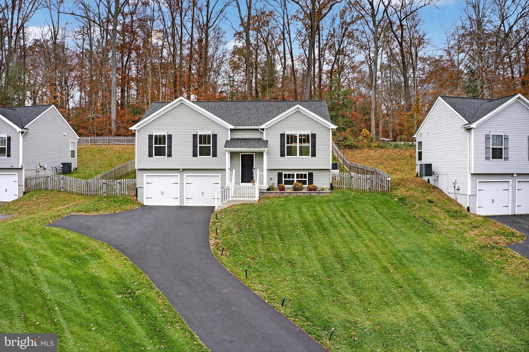 a front view of a house with a garden and trees