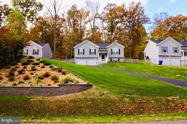 a view of a house with a big yard and large trees