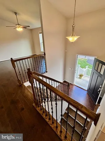 a view of staircase with railing and a chandelier