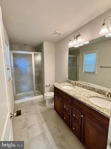 a spacious bathroom with a granite countertop sink mirror and shower