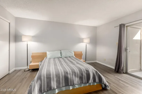 a bedroom with a bed and wooden floor